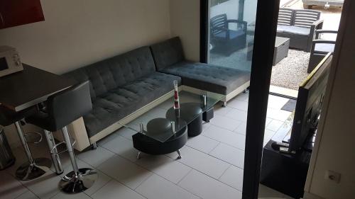 uma sala de estar com um sofá e uma televisão em T2 valentina em Rognac
