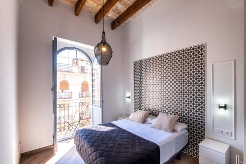 a bedroom with a bed and a large window at Spacious Penthouse with Massive Terrace in Valencia