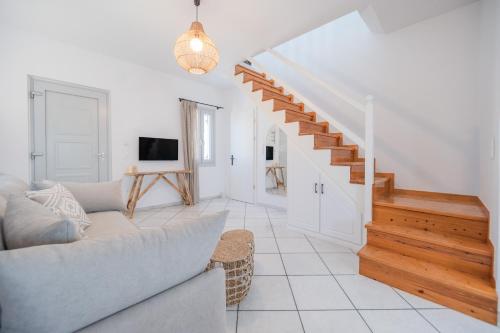 ein Wohnzimmer mit einem Sofa und einer Treppe in der Unterkunft Disis Residence in Naxos Chora