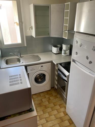 La cuisine est équipée d'un évier, d'une cuisinière et d'un réfrigérateur. dans l'établissement Appartement proche mer, à Valras-Plage