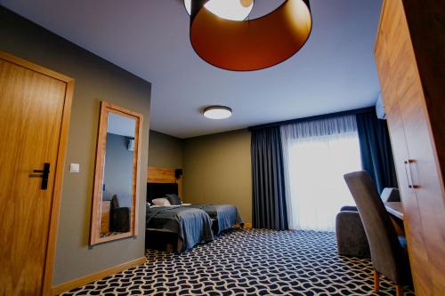 a hotel room with two beds and a mirror at Hotel Coloseum in Jarosław