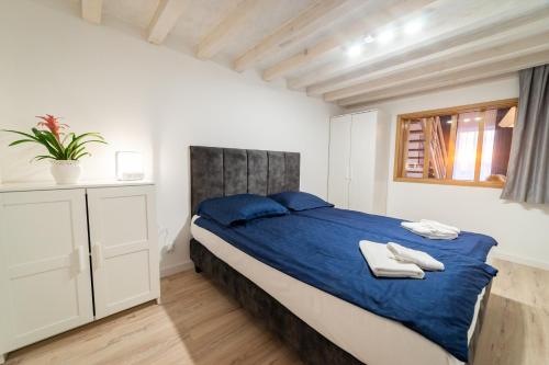 sypialnia z łóżkiem z niebieską pościelą i oknem w obiekcie Apartamenty na Prusa w mieście Mikołajki