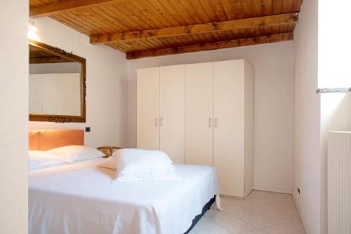 a bedroom with two white beds and a mirror at Dimora Vittoria - Lago Maggiore in Casalzuigno