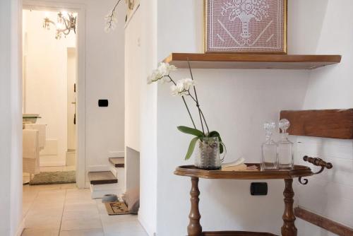 a hallway with a table with a vase of flowers on it at Dimora Vittoria - Lago Maggiore in Casalzuigno