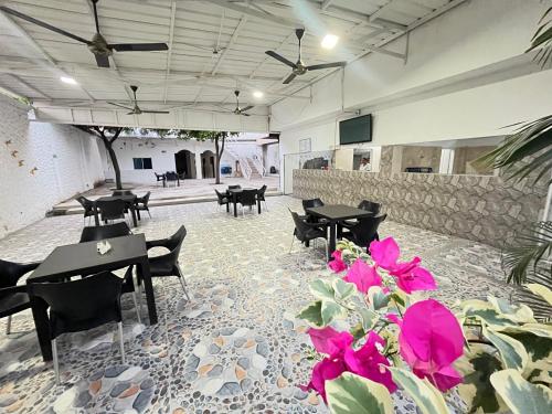 a dining room with tables and chairs and flowers at HOTEL BOSCONIA IMPERIAL in Bosconia