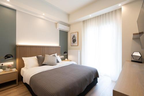 een slaapkamer met een bed en een groot raam bij Newly Renovated 2 Bedroom Apartment, 5min to metro in Athene