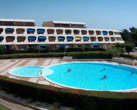 une grande piscine devant un immeuble dans l'établissement Studio 21m2 Port-Camargues, le Grau du Roi, au Grau-du-Roi