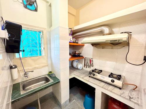 a small kitchen with a sink and a stove at Classic 2BHK Serviced Apartment beside Jadavpur University in Kolkata
