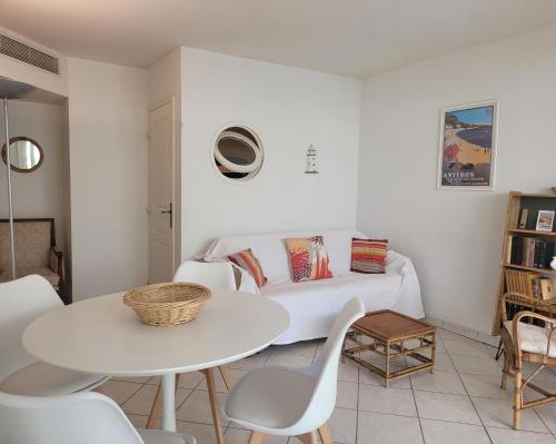 un salon blanc avec une table et des chaises blanches dans l'établissement LE 5 TANIT, à Antibes