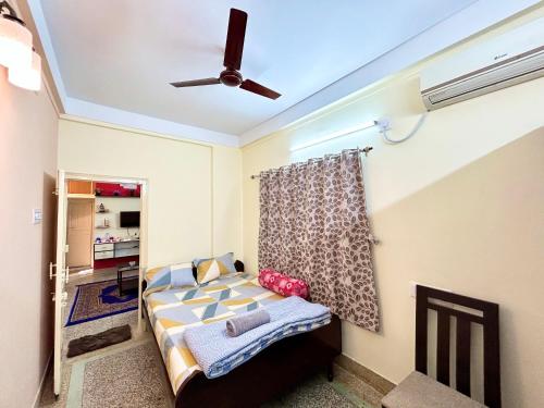a bedroom with a bed and a ceiling fan at Classic 2BHK Serviced Apartment beside Jadavpur University in Kolkata