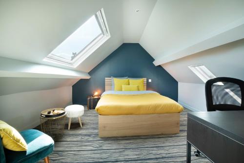 a attic bedroom with a bed and a window at Maison et Jardin - Chambre Cosy in Amiens