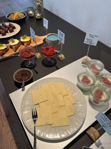 a table with a plate of cheese and other food at Hotel Steenbergs in Nykøbing Mors