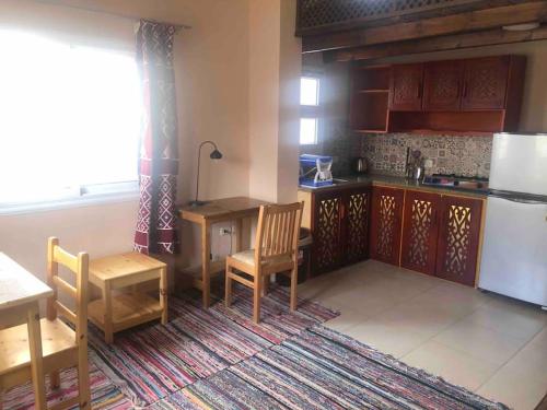 a kitchen with a table and chairs and a refrigerator at Dahab Relax Studio 2 in Dahab