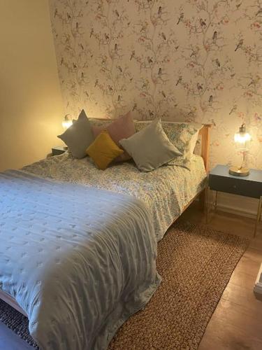 Un dormitorio con una cama con almohadas. en West London stunning garden flat - period features, en Londres