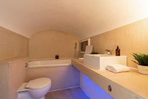 a bathroom with a toilet and a tub and a sink at Stay Kensington & Chelsea in London