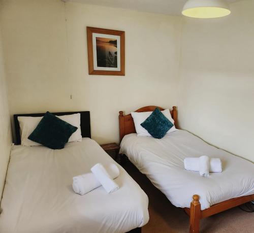2 camas en una habitación con sábanas blancas en The Fox Inn, en Souldern