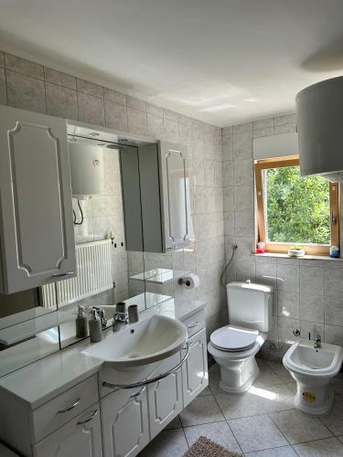 a white bathroom with a sink and a toilet at Apartment Tiffany in Solin