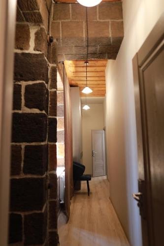 a hallway with a brick wall and a room with a chair at ZERO GUESTHOUSE in Gyumri