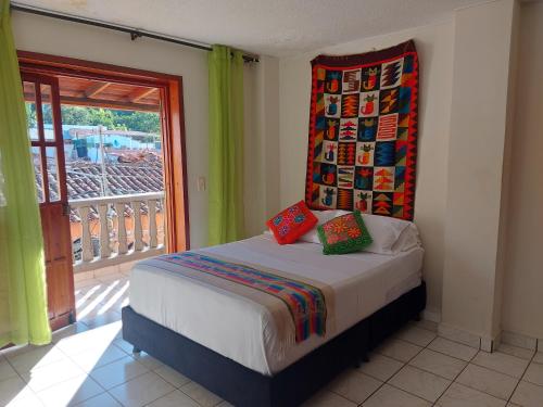 a bedroom with a bed and a window with a balcony at Encantador apartahotel en el centro de San Gil in San Gil