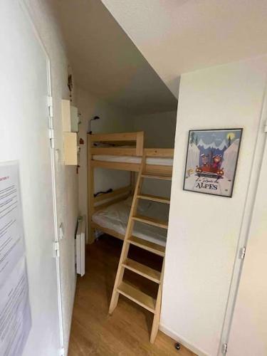 Cette petite chambre comprend des lits superposés et une échelle. dans l'établissement App 4-6 pers avec 1 place garage 100m pistes plein centre, à Les Deux Alpes