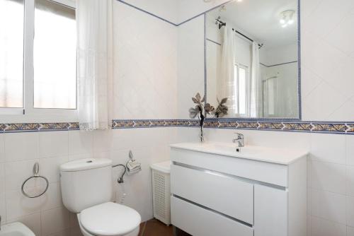 ein Badezimmer mit Toilette, Waschbecken und Spiegel in der Unterkunft Villa Juani Sólo familias in Roche