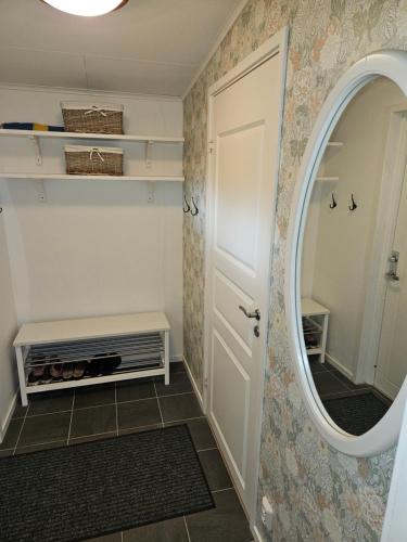 a bathroom with a door and a mirror at Mysig stuga i naturskönt område. in Vetlanda