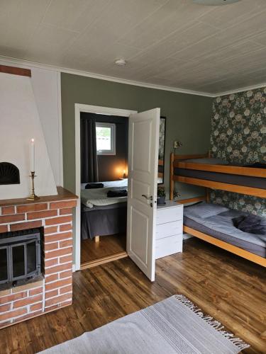 a room with two bunk beds and a fireplace at Mysig stuga i naturskönt område. in Vetlanda