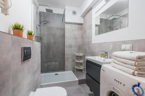 W łazience znajduje się prysznic, umywalka i pralka. w obiekcie Imperial Apartments - Baltica w mieście Sopot