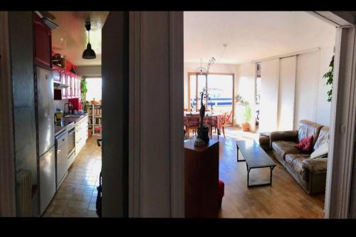 a kitchen and a living room with a couch and a table at Le charme de Montmartre à ciel ouvert in Paris
