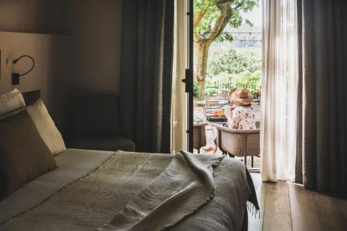 a bedroom with a bed and a door to a patio at Les Lodges Sainte-Victoire Hotel & Spa in Aix-en-Provence