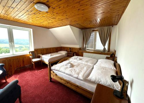 a bedroom with two beds and a wooden ceiling at Obří Sud Libverda *** in Lázně Libverda