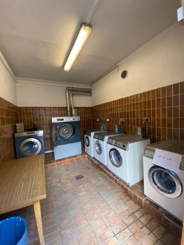 eine Waschküche mit zwei Waschmaschinen sowie einer Waschmaschine und einem Trockner in der Unterkunft AllYouNeed Oktoberfest Basic Camping in München
