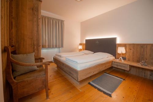 a bedroom with a bed and a chair in it at Steidlerhof in Bolzano