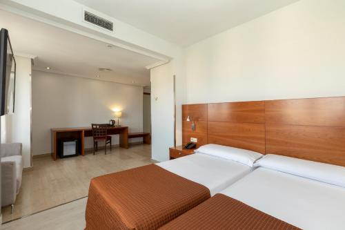 a hotel room with a bed and a desk at Porcel Torre Garden in Madrid