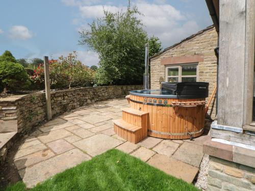 a hot tub sitting outside of a house at Stag Cottage in Macclesfield