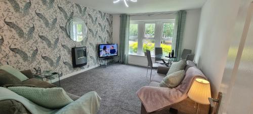 a living room with two couches and a tv at The Pennington Apt with Wifi and FREE Parking Next to Sports Village in Leigh