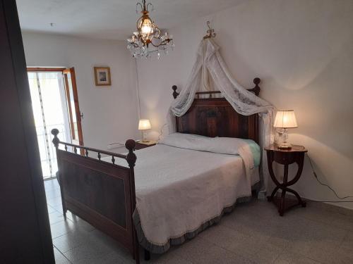 Ravigliano的住宿－Il Casale degli Artisti，一间卧室配有一张带天蓬的大床