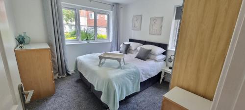 a bedroom with a bed with a table on it at The Pennington Apartment & FREE Parking Next to Sports Village in Leigh