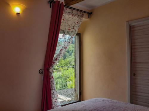 1 dormitorio con ventana y cortina roja en Apartment with private terrace, shared hydro and pool, en Pugliano