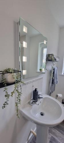 a white bathroom with a sink and a mirror at The Pennington Apt with Wifi and FREE Parking Next to Sports Village in Leigh