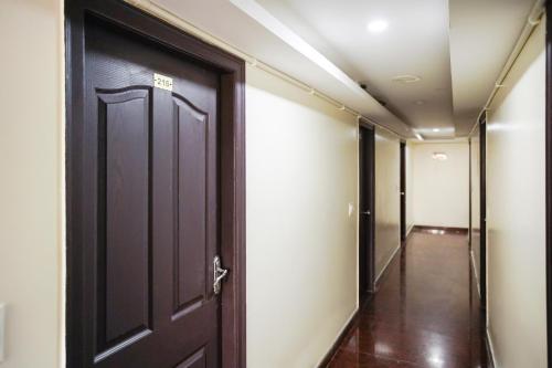 an open door in a hallway with a corridor gmaxwell gmaxwell gmaxwell gmaxwell gmaxwell gmaxwell gmaxwell at OYO Flagship Hotel J.B. Paradise in Vānivilāsa Puram