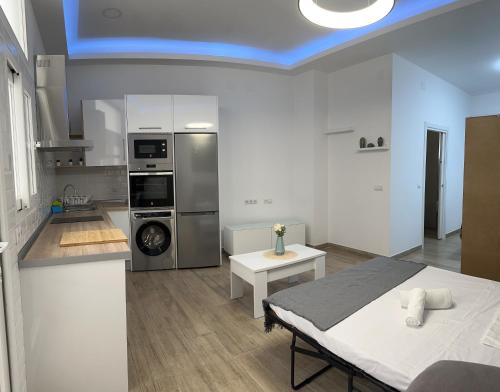 uma cozinha com uma cama e uma mesa num quarto em Sky Garden Málaga Centro em Málaga
