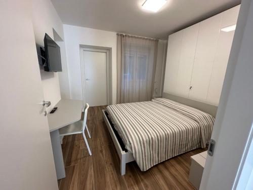 een kleine slaapkamer met een bed en een bureau bij San Pellegrino Suites in San Pellegrino Terme