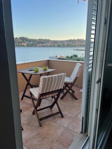 a balcony with a table and chairs and a view of the water at Apartman Elena in Verunić