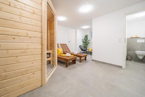 a living room with a wooden wall and a mirror at CNSc422 - 2-Raum Appartement in Cappel-Neufeld