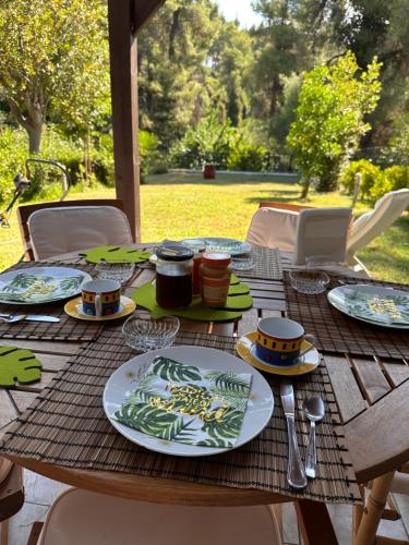 uma mesa de madeira com pratos de comida em Sani forest house em Sani Beach