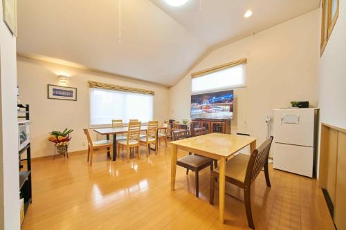 a dining room with tables and chairs and a refrigerator at Guest House Kingyo - Vacation STAY 14497 in Sapporo