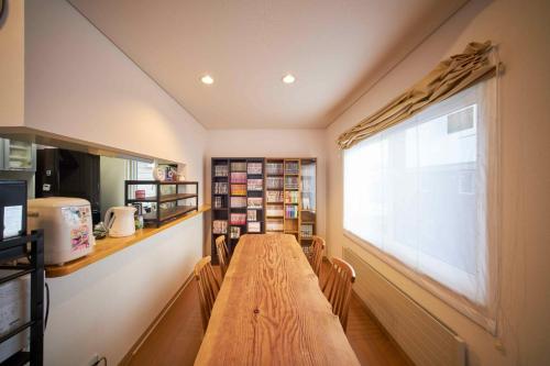 Guest House Kingyo - Vacation STAY 14497 في سابورو: غرفة طعام مع طاولة خشبية ونافذة