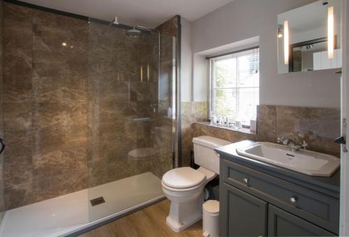 a bathroom with a toilet and a sink and a shower at Sherborne House in Chipping Campden