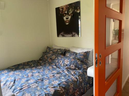 1 dormitorio con 1 cama y una pintura en la pared en WALO APARTMENTS Tromsø - Alfheim 10 min walk to city centre, en Tromsø